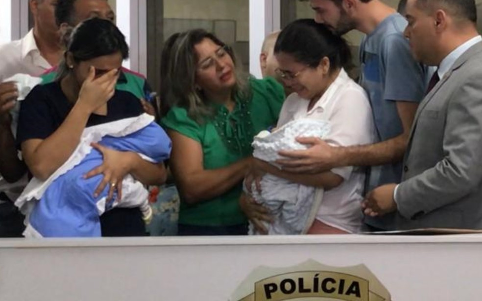 Pauliana e Aline choram ao fazer a destroca dos bebês, Trindade, Goiás — Foto: Vitor Santana/G1